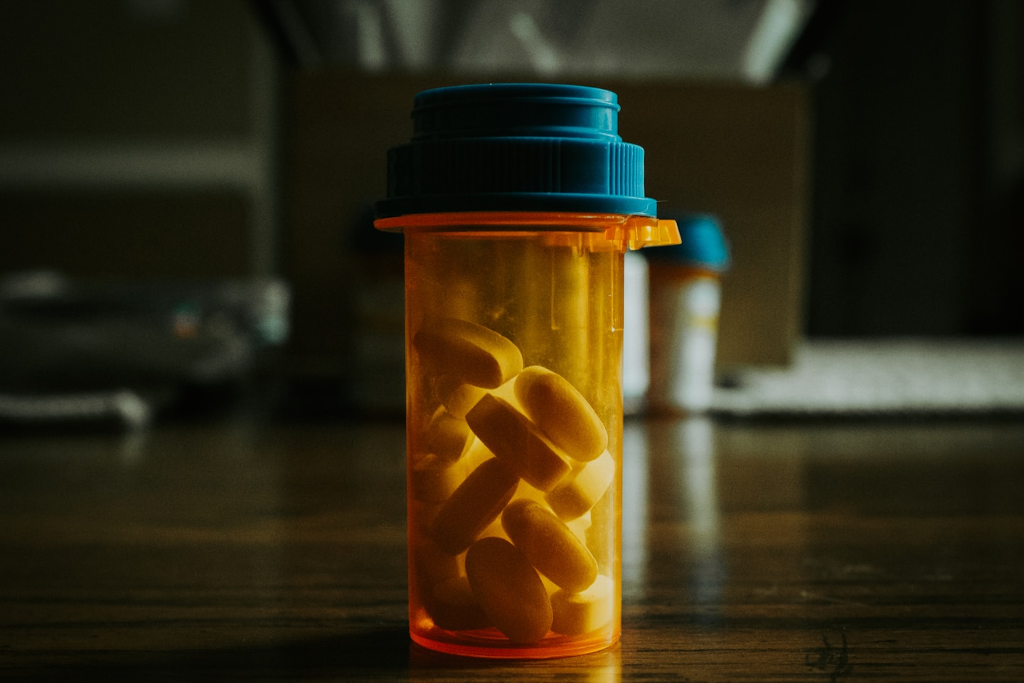 a bottle filled with pills sitting on top of a wooden table
