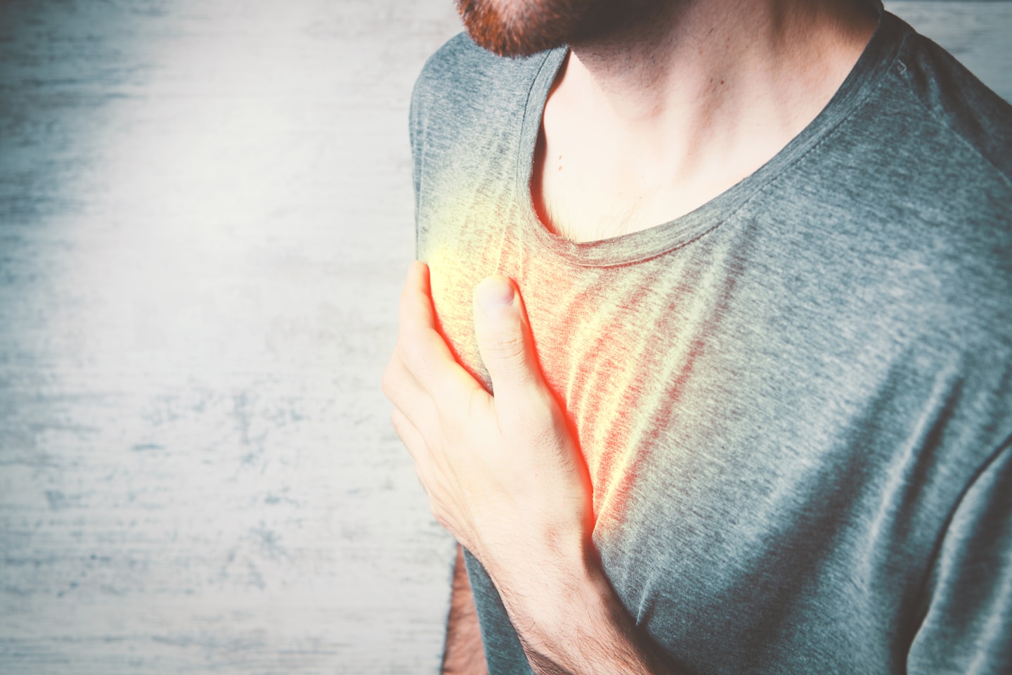 a man holding his chest with his hands